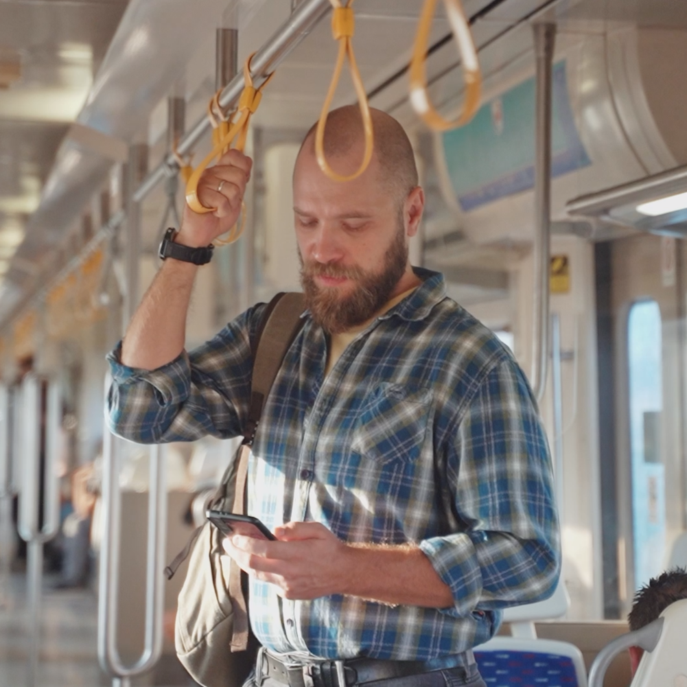 Man watching his phone in a bus