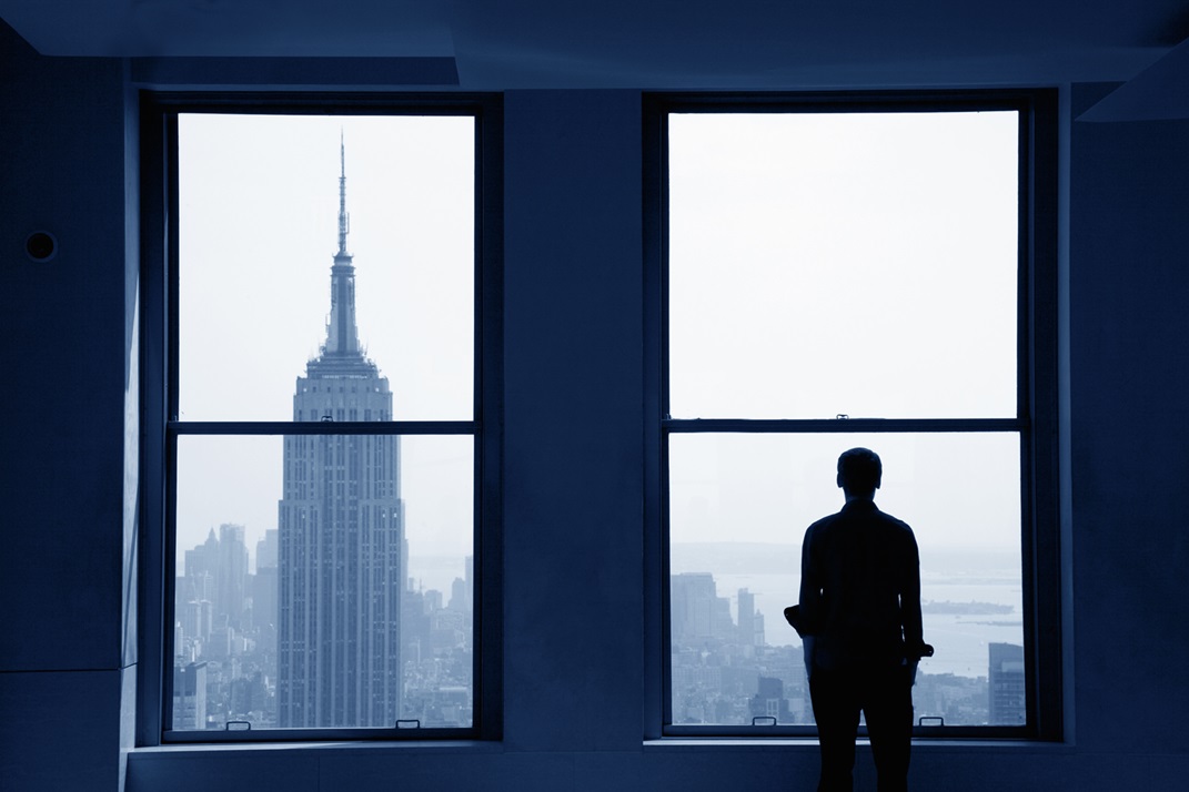 man looking out of the window of a building