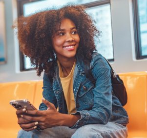 Frau mit Smartphone in der Bahn