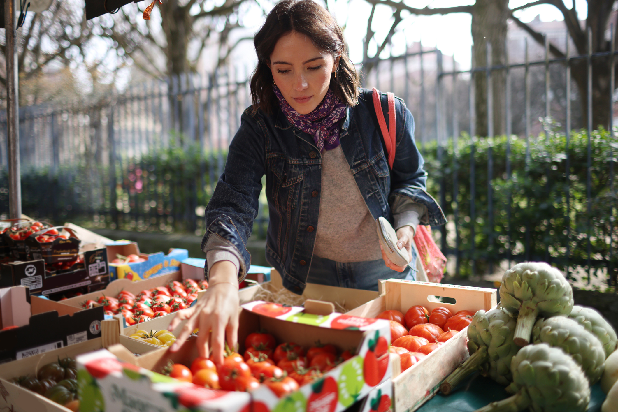 Femme au marché en train de choisir des tomates
