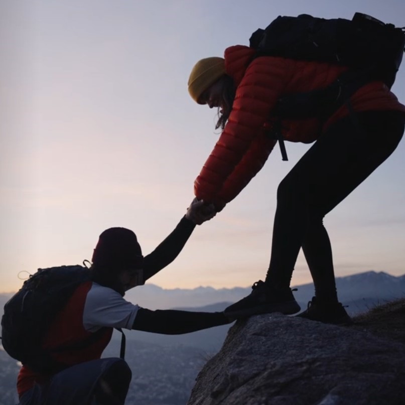 2 people climbing a mountain